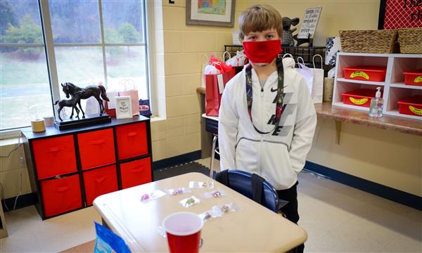 student stands next to desk during Market Day